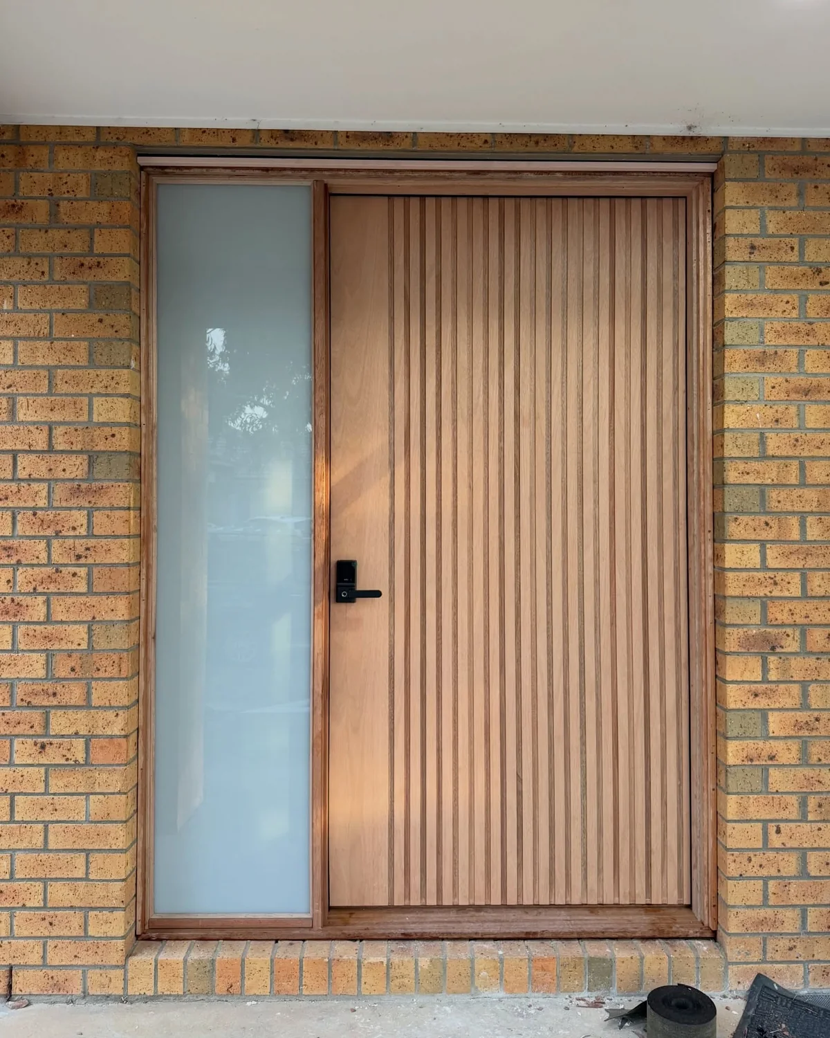 Custom oversized walnut entry door installed by Takshak Built in Sanctuary Lakes, Point Cook